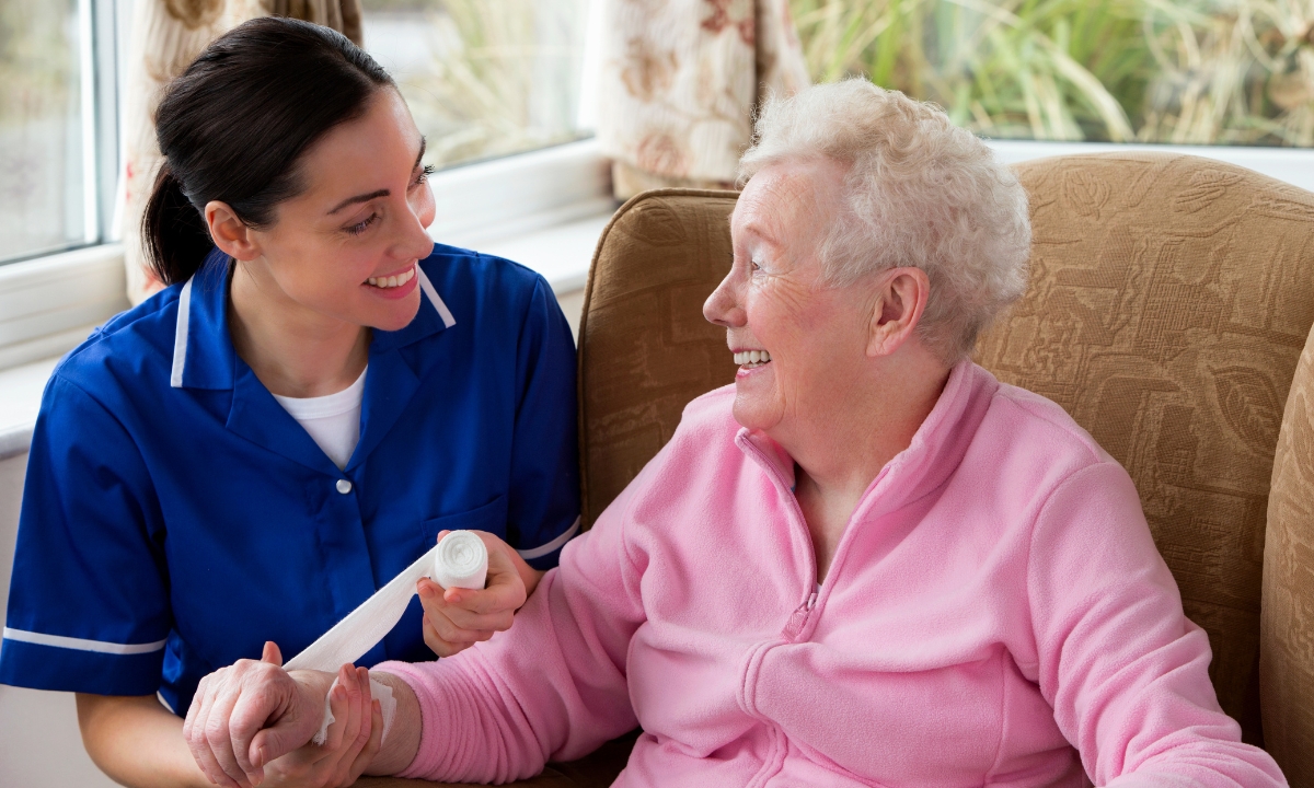 Smiling elderly woman receiving support from a carer in a home setting, illustrating the compassionate nature of live in care services.