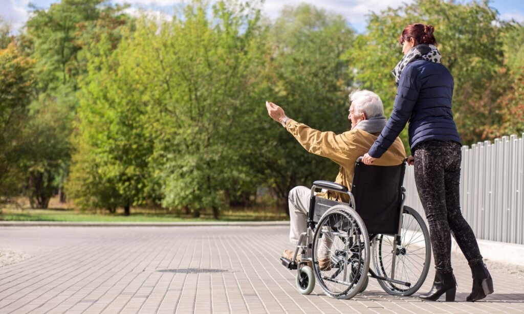 Carer pushing a disabled adult in a wheelchair, symbolising compassionate and supportive respite care for disabled adults