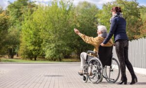Carer pushing a disabled adult in a wheelchair, symbolising compassionate and supportive respite care for disabled adults