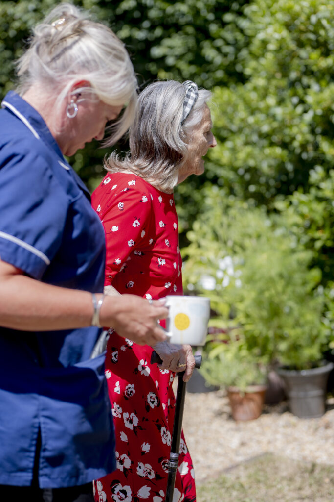 Carer from Choice Care 4U assisting an elderly woman walking in the backyard, providing compassionate live in home care support.