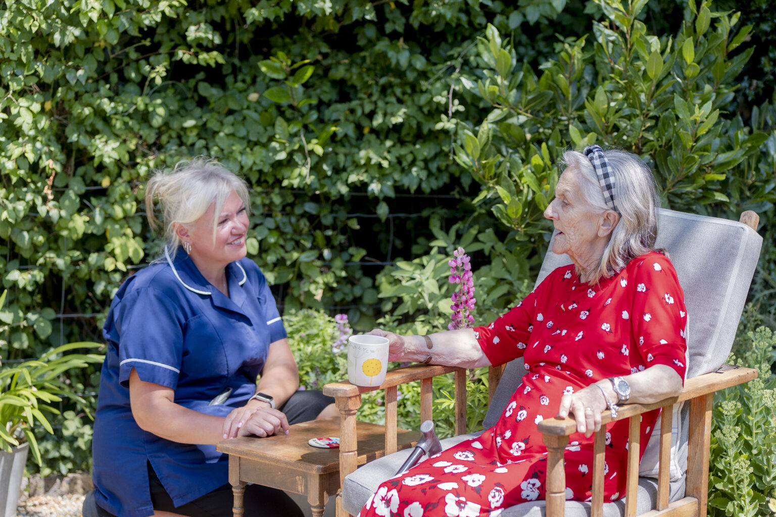 Friendly carer providing care at home services for elderly while talking with an elderly woman