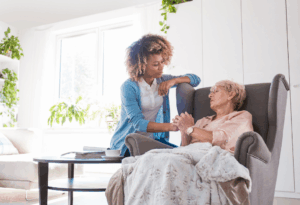 A compassionate carer holding the hand of a senior in a wheelchair, symbolizing trust and support, ideal representation of emergency home care services.
