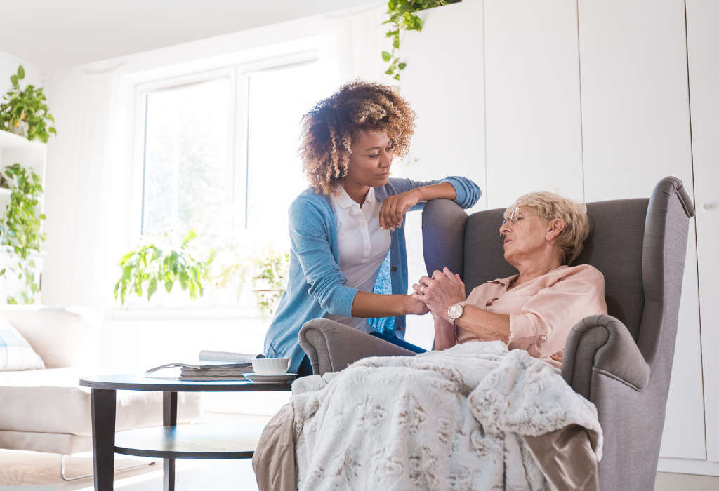 A compassionate carer holding the hand of a senior in a wheelchair, symbolizing trust and support, ideal representation of emergency home care services.