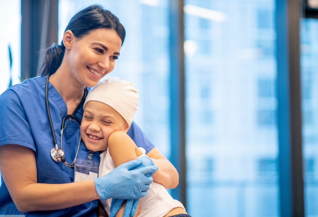 Compassionate carer providing emotional support by hugging a young child cancer patient during In Home Cancer Care.