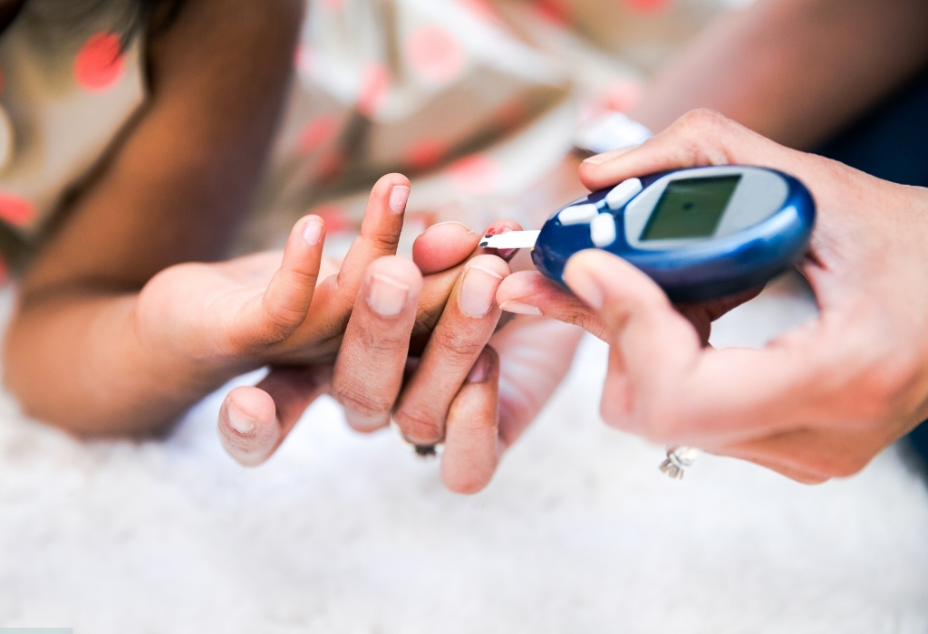 Blood test being done on a patient’s hand for diabetes at home, monitoring blood sugar levels.