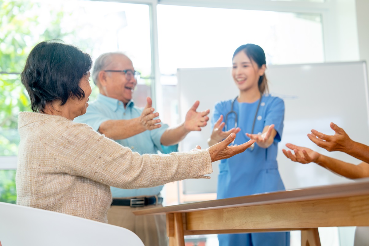 Adults exercising at home with a friendly carer, highlighting support and independence, illustrating care at home eligibility in West Sussex.