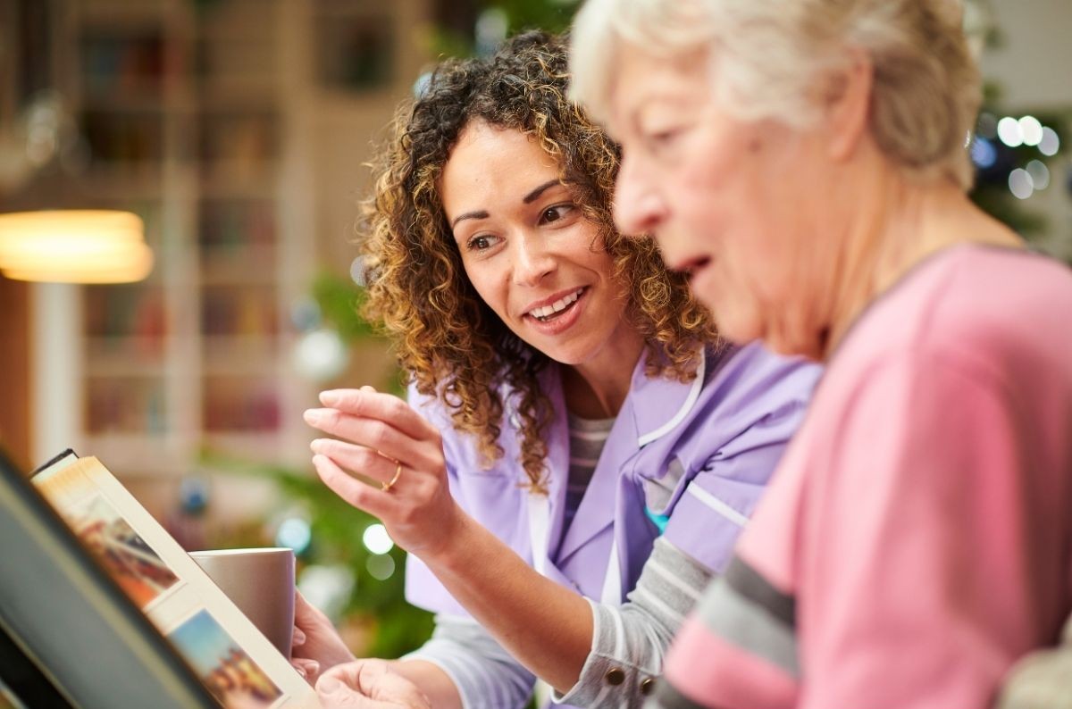A carer talking to an old woman which could qualify for state-funded home care in England